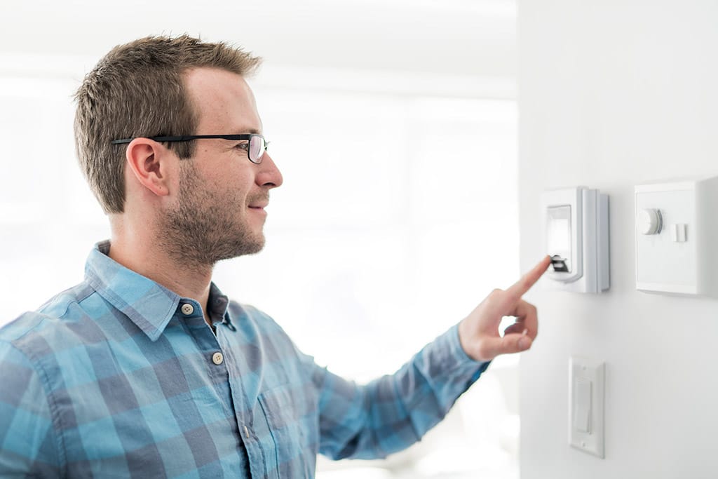 Man trying to turn on HVAC unit with thermostat