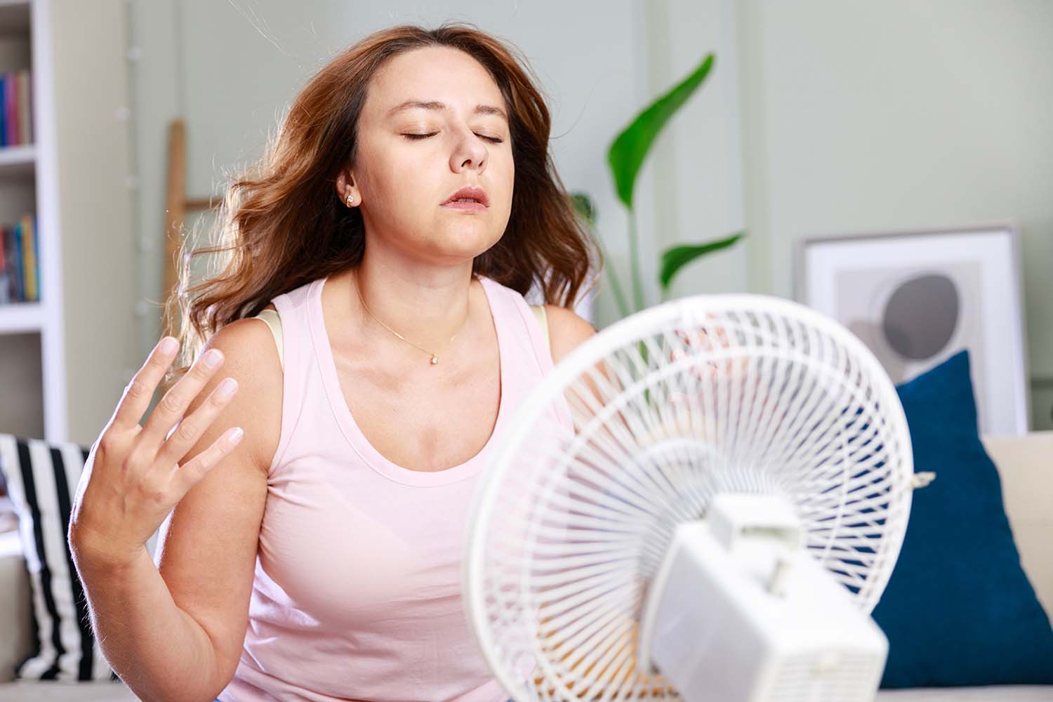 person in front of fan trying to cool off in her humid house