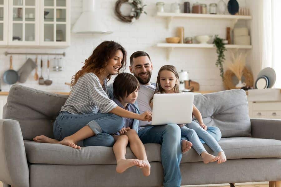 family enjoying comfortable time together on a couch in their home.