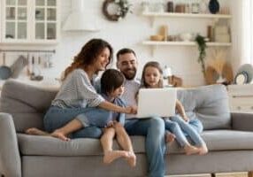 family enjoying comfortable time together on a couch in their home.